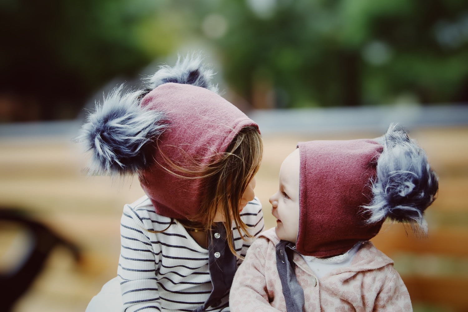 sisters in brimless bonnet pompom hats fireside wool